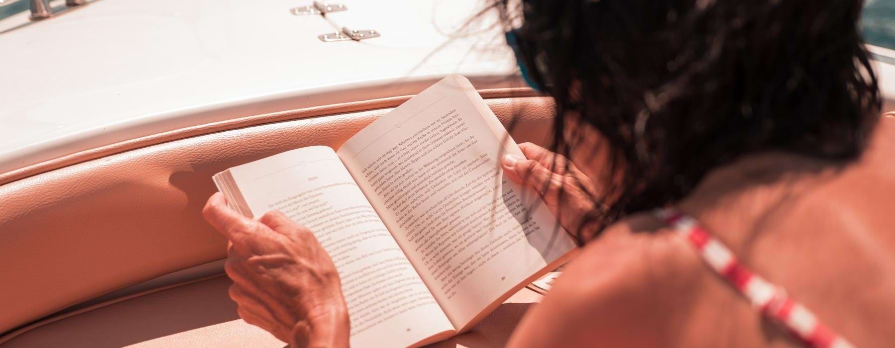 a person reading a book on a boat
