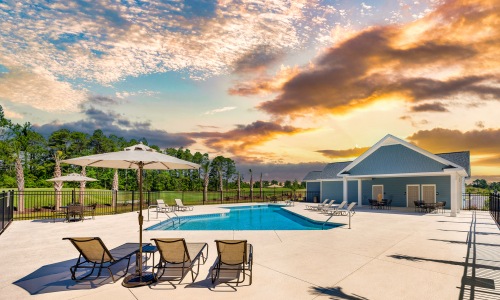 Twilight image of pool with deck chairs